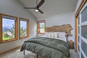 a bedroom with a bed with a ceiling fan and windows at Evergreen Mountain Duplex with Trail Access! in Idaho Springs