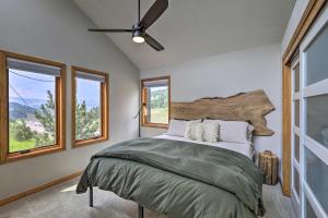 a bedroom with a bed with a ceiling fan and windows at Evergreen Mountain Duplex on I70 with Trail Access! in Idaho Springs