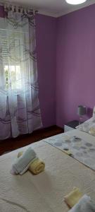 扎達爾的住宿－Apartmani Katarina，紫色卧室,床上配有2条毛巾
