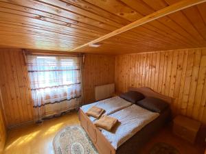 1 dormitorio con 1 cama en una habitación de madera en Pid Playem en Volovets