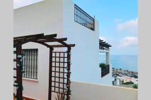a building with a gate and a balcony with the ocean at Penthouse with large terrace and roof solarium, with amazing sea views in Mojácar