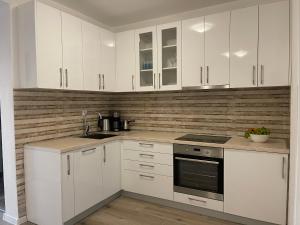 a kitchen with white cabinets and a stove top oven at Villa Roki in Ravanj