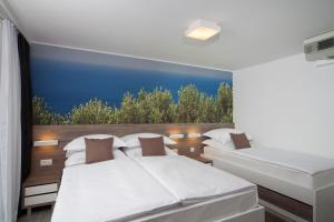 two beds in a room with a view at Bluesun hotel Neptun - All inclusive in Tučepi