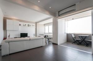 a large white room with a couch and a table at Amazing Apartment in Costa da Caparica in Costa da Caparica