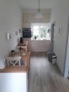 a kitchen with wooden tables and a kitchen with a window at Gutshof Rothensande in Waabs