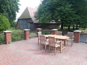 a wooden table and chairs on a brick patio at Gutshof Rothensande in Waabs