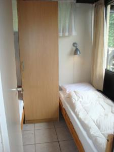 een kleine slaapkamer met een bed en een deur bij Gardameer-Tignale-Hasewinkel in Tignale