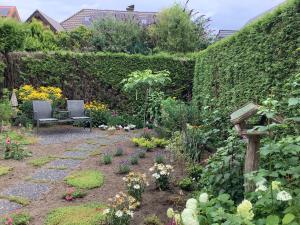 a garden with a bench and some flowers at Helle freundliche Wohnung 50qm mit Garten zum Wohlfühlen in Vreden