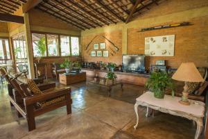 ein Wohnzimmer mit Sofa und Fernseher in der Unterkunft Pousada Verbicaro in Santa Maria Madalena