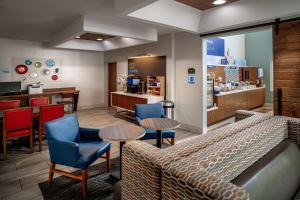 a waiting room with chairs and tables and a counter at Holiday Inn Express and Suites Pikeville, an IHG Hotel in Pikeville