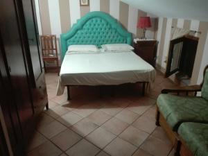 a bedroom with a large bed with a blue headboard at B&B Casa Armonia in Pizzo