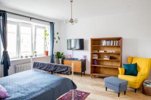 1 dormitorio con 1 cama y 1 silla amarilla en Cosy Apartment 2, en Cracovia