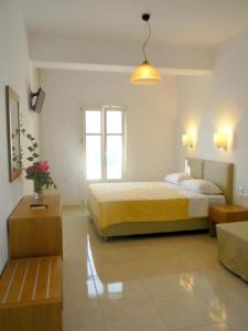 Habitación blanca con cama y ventana en Anatoli Rooms, en Egíali