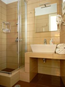 a bathroom with a sink and a shower at Anatoli Rooms in Aegiali