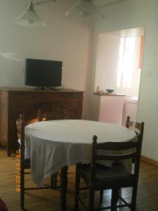 a dining room with a table and a television at Maison de campagne MONTCUQ en Quercy Blanc in Montcuq