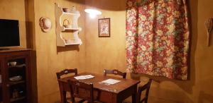 comedor con mesa y cortina en Agriturismo Fiore di Campo, en Fermo