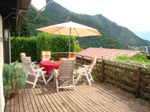 een tafel en stoelen met een parasol op een terras bij Gardameer-Tignale-Hasewinkel in Tignale