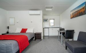 Schlafzimmer mit einem Bett, einem Schreibtisch und einem Stuhl in der Unterkunft Welcome Inn Motel Levin in Levin