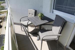 2 sillas y una mesa en el balcón en H2O en Zalakaros