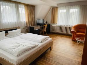 Schlafzimmer mit einem Bett, einem Schreibtisch und einem Stuhl in der Unterkunft Landhotel "Wettin" in Neuhermsdorf