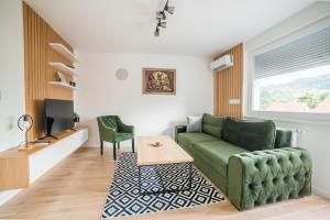 - un salon avec un canapé vert et une table dans l'établissement Liberty Apartments, à Tuzla