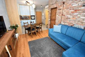 - un salon avec un canapé bleu et un mur en briques dans l'établissement Apartament Blue Bastion Wałowa 23c z klimatyzacją i miejscem parkingowym w podziemnym parkingu, à Gdańsk