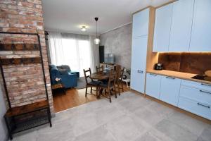 une cuisine et une salle à manger avec un mur en briques dans l'établissement Apartament Blue Bastion Wałowa 23c z klimatyzacją i miejscem parkingowym w podziemnym parkingu, à Gdańsk