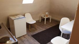 een kleine kamer met witte stoelen en een kleine tafel bij Monteurzimmer mit Gemeinschaftsbad in Brebach in Saarbrücken