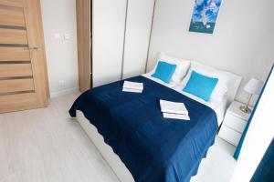 sypialnia z łóżkiem z niebieską pościelą i niebieskimi poduszkami w obiekcie Apartament 7M z Basenem w jednym budynku Rewal, free private parking, Park rozrywki HOSSOLAND 30 minut w Rewalu +37 zdjęć