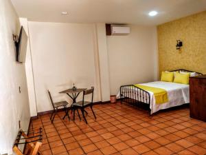 a bedroom with a bed and a table in it at Casa de las flores Hotel Boutique in Huajuapan de León