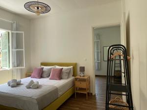 - une chambre avec un lit doté d'oreillers roses et d'une échelle dans l'établissement Via De Bosset City Cottage, à Argostóli