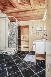 y baño con ducha, lavabo y bañera. en Chalet Dacha mit finnischer Sauna en Zell am See