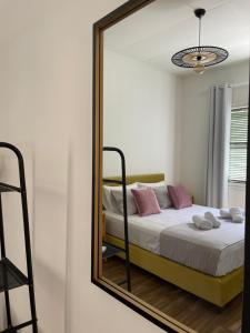 - un miroir reflétant un lit dans une chambre dans l'établissement Via De Bosset City Cottage, à Argostóli