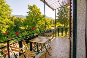 balcón con mesa, sillas y flores en Danilo's Resort, Vipavska dolina, en Dobravlje