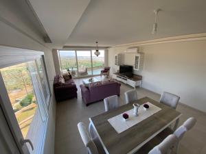 a dining room with a table and chairs and a living room at Vista Panorama Kusadasi in Kuşadası