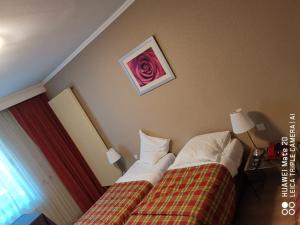 una habitación de hotel con una cama con una flor en la pared en Hôtel La Côte d'Or, en Philippeville