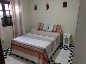 een bed in een slaapkamer met een geruite vloer bij chaler Sao Jorge in São Pedro