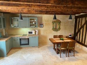 a kitchen with blue cabinets and a wooden table at 16 CHEMIN DE BOISBELET in Coutras