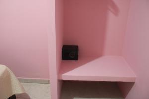 um quarto rosa com um banco com um altifalante em Hotel Boutique La Orquidea em Coatepec