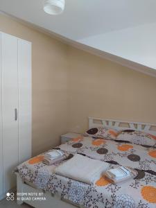 a bedroom with a bed with towels on it at Apartman Andjela in Kavač