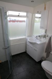 a bathroom with a sink and a toilet and a window at Star Guesthouse in Reykjavík