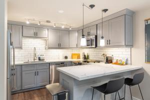 a kitchen with gray cabinets and a white counter top at Madison Park Seattle with Outdoor Private Garden and Grill 1BR 1BA in Seattle
