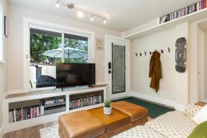 sala de estar con TV y sofá en Madison Park Seattle with Outdoor Private Garden and Grill 1BR 1BA en Seattle