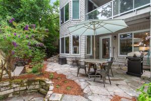 a patio with a table and chairs and an umbrella at Madison Park Seattle with Outdoor Private Garden and Grill 1BR 1BA in Seattle