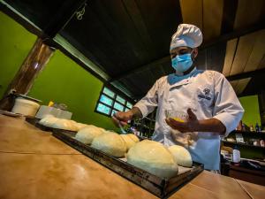 un chef de pie en una cocina preparando comida en Playa Selva Lodge, en Archidona