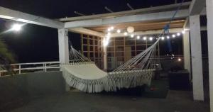 een hangmat hangend aan een veranda 's nachts bij DB Tower Vacation Rental in Belize City
