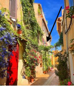 an alley with flowers on the side of a building at Appartement le Quai du Port Cassis parking clim in Cassis