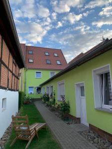 un patio de una casa con un banco y un edificio en Ferienwohnung Zur Glewe, en Neustadt-Glewe