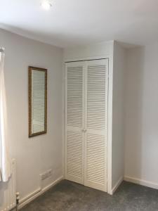 
a room with a white door and a white toilet at 1 Phoenix Cottages, 403 High Street, Cheltenham in Cheltenham
