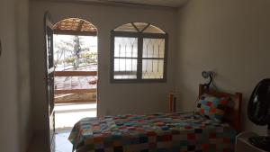 a bedroom with a bed and an open window at Recanto do Surf in Saquarema